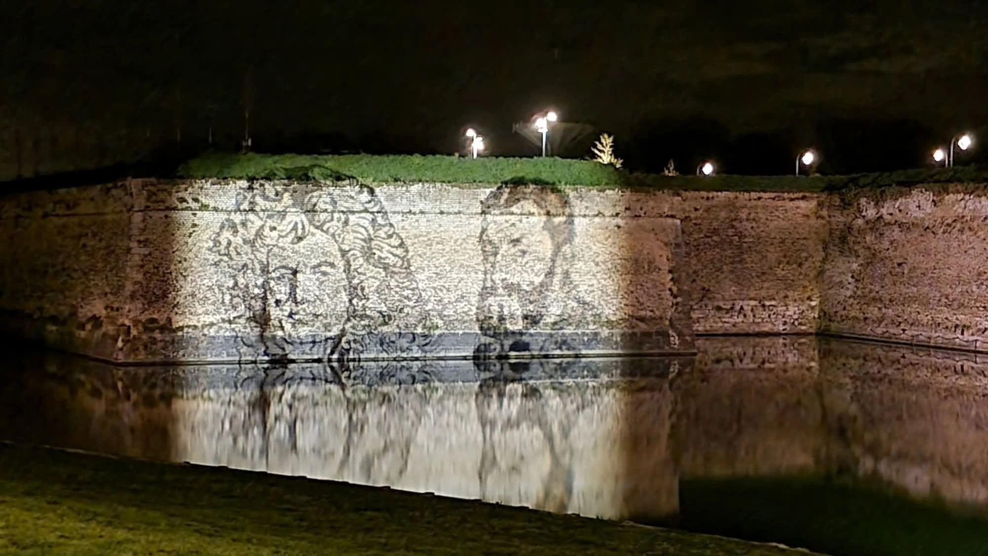 Portrait projeté sur les remparts, reflet dans l'eau